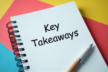 A person writing key takeaways in a notebook