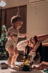 A heartfelt moment of celebration where mother and child decorate a festive tree together Mother and son celebrate winter holiday together decorating tree with ornaments in cozy family evening filled