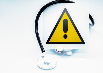Black stethoscope showing warning sign for medical attention, health risk and healthcare emergency