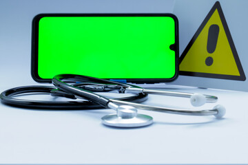 Medical equipment including stethoscope, smartphone with chroma key display and warning sign...