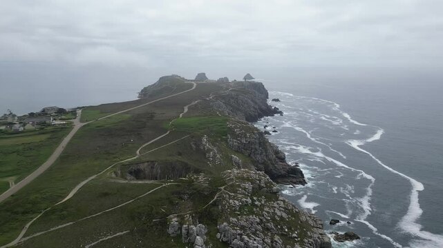 Drone footage of the rocky coastline at Pointe de Pen-Hir on the Crozon Peninsula, Brittany, France, on a cloudy day.