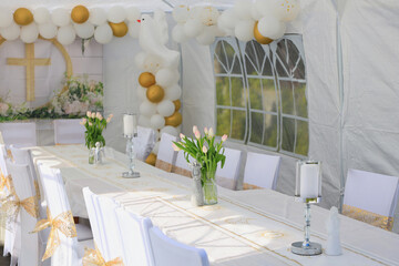 Garden tent for a communion party with a table and white decorations.