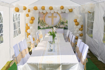 Garden tent for a communion party with a table and white decorations.