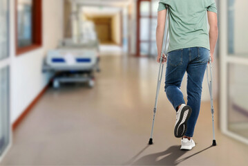Man with axillary crutches in hospital, closeup. Space for text