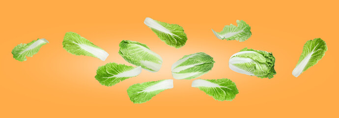 Fresh Chinese cabbages and leaves flying on orange gradient background
