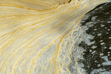 Dirty foam on the surface of the water. Pollution of water bodies by waste from the chemical industry. Environmental pollution, background.