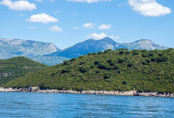 A colourful scene of green hills and mountains overlooking the Bay of Kator