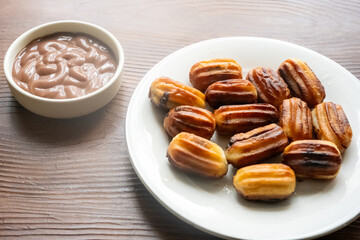 Close-up of churros dessert on a white vintage plate and hot chocolate