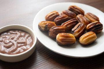 Close-up of churros dessert on a white vintage plate and hot chocolate