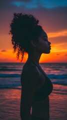 Silhouette of a woman at sunset on the beach.