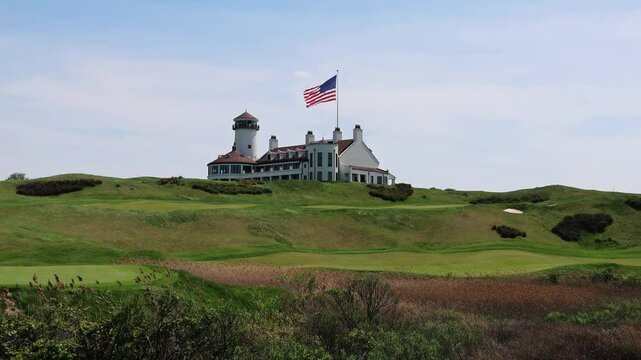 usa flag waving next to building at golf course in bayonne new jersey (united states of america green meadow freedom breeze wind) grass sport