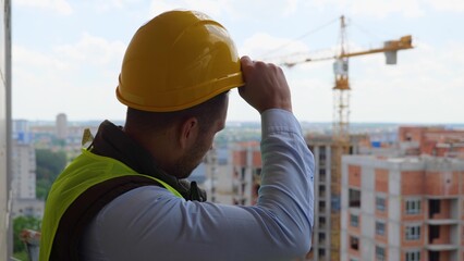 Close up portrait of Caucasian handsome professional male builder in uniform standing at...