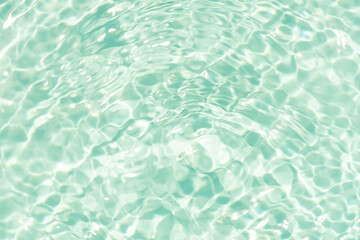 Blue water with ripples on the surface. Defocus blurred transparent blue colored clear calm water surface texture with splashes and bubbles. Water waves with shining pattern texture background.