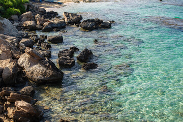 Rocky coastline with crystal-clear turquoise water on a sunny day in Cyprus...