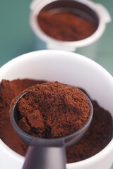 Coffee grounds in a measuring scoop on a kitchen countertop