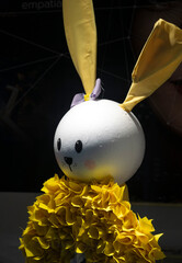 Easter handmade bunny in yellow against a black background.