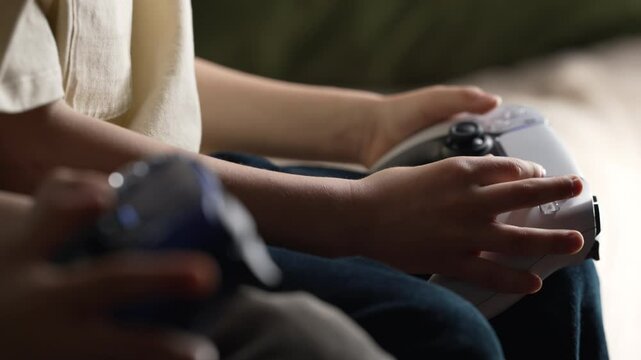 Young boys presses buttons, using joypad controller, wireless gamepad. Hobby.