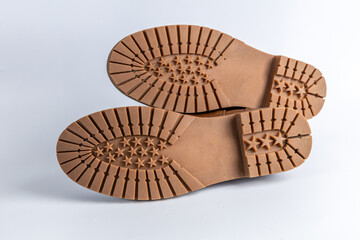 Detailed view of brown shoe soles with star design and rugged tread. Fashionable and functional footwear for outdoor wear.