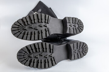 Detailed view of black boot soles with textured grip and high traction. Heavy-duty design for comfort and performance.