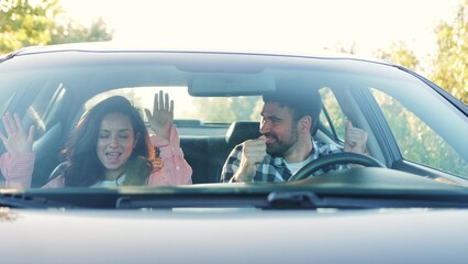 Happy couple making party in the car while driving. Slow motion