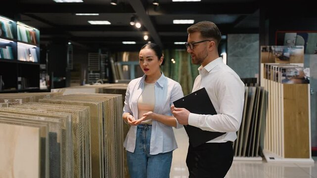 Consultant advising customer choosing tiles in showroom