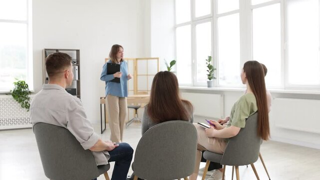Mentor and group of people having meeting during life coaching class indoors