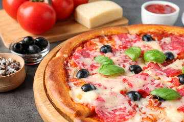 Tasty pizza and ingredients on grey table, closeup