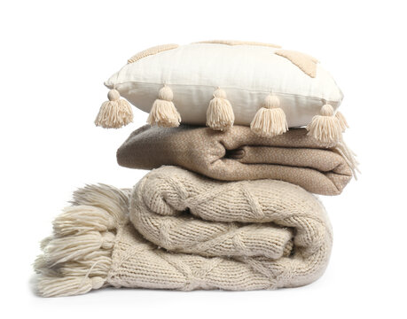 Folded woolen blankets and pillow isolated on white