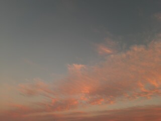 A pink cloud floats across the sky like cotton wool. Copy space.