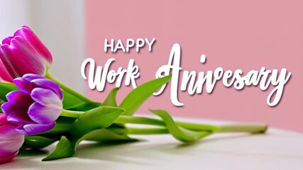 Tulip flowers and pink card saying happy work anniversary on table scene