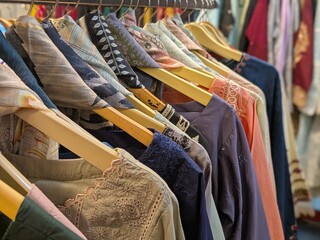 a photograph of a store full of a variety of colorful clothing items, including shirts