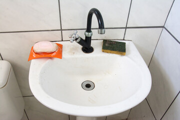White toilet bowl and washbasin in a public restroom, brazil