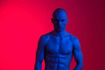 Artistic portrait of a muscular man with blue skin, set against a vibrant red background. This striking, colorful image evokes a sense of strength and confidence.