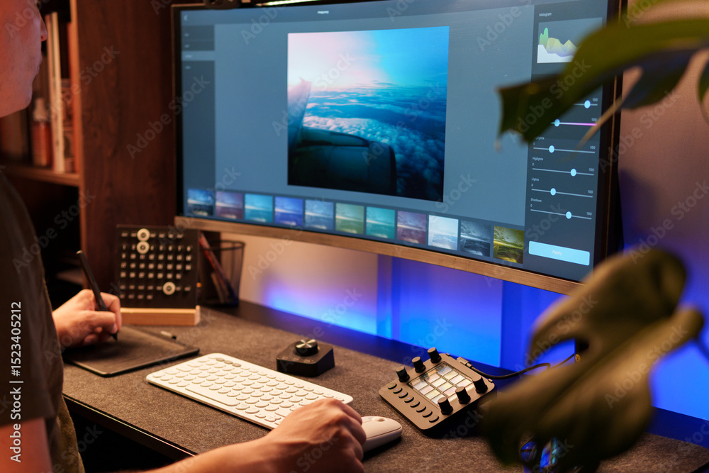 Fototapete photographer retouching an aerial cloudscape photo on a computer using professional editing software