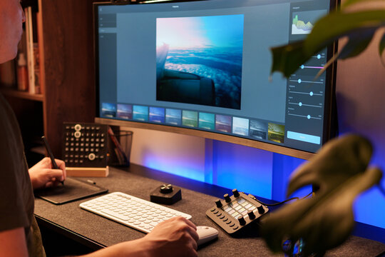 Photographer retouching an aerial cloudscape photo on a computer using professional editing software