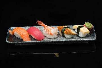 salmon, tuna, prawn, eel, tamago, nigiri sushi on a plate 