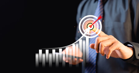 Businessman pointing at virtual hologram chart of financial and marketing business growth analysis...