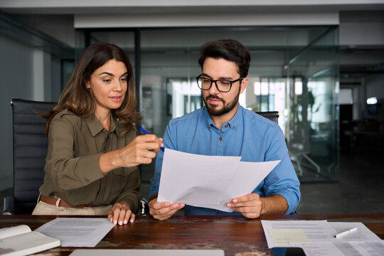 Fototapeta Financial planning, advisory service concept. Female advisor attorney lawyer or bank manager consulting client investor reading document at business meeting reviewing legal paper working in office.