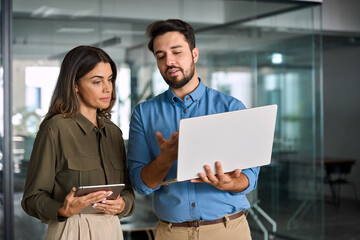 Busy female executive manager talking to male colleague having conversation showing software online...