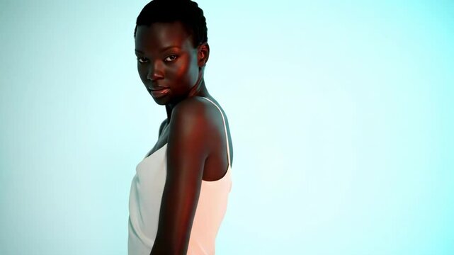 A model poses elegantly in a minimalist white dress against a soft blue backdrop, showcasing fashion and beauty in a studio setting - sexy skinny black chick