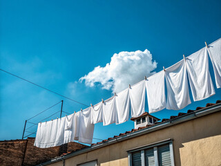 Close-up of blue sky and white laundry. Clean. Clear skies. No people. Rooftop of a building.