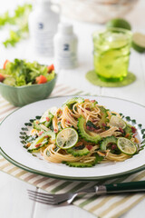 【ゴーヤと梅肉のパスタ】さっと茹でたゴーヤと梅肉・大葉・松の実を和えた夏のパスタ。仕上げに酢橘のスライスを散らして爽やか風味を楽しみます。