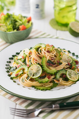 【ゴーヤと梅肉のパスタ】さっと茹でたゴーヤと梅肉・大葉・松の実を和えた夏のパスタ。仕上げに酢橘のスライスを散らして爽やか風味を楽しみます。