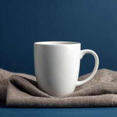 White Speckled Mug on Neutral Textile Against Dark Blue Background