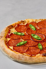 Classic pepperoni pizza with rustic crust and vibrant overhead lighting on neutral background