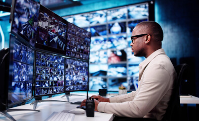 Male African-American CCTV Operator Monitors Multiple Screens