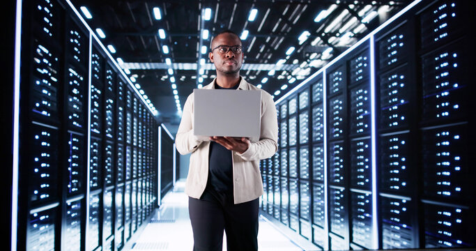 Smiling IT Specialist Configuring Servers In Data Center - Powered by Adobe