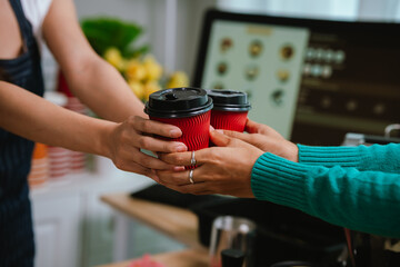 A smiling barista serves a customer at a modern café counter, showcasing friendly service, small business spirit, and coffee culture.