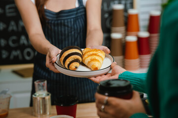 A smiling barista serves a customer at a modern café counter, showcasing friendly service, small business spirit, and coffee culture.