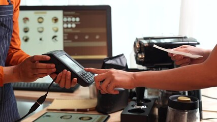 A smiling barista serves a customer at a modern café counter, showcasing friendly service, small business spirit, and coffee culture.